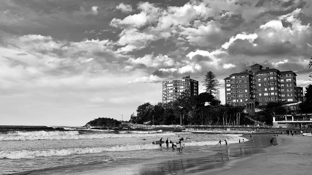 grayscale photo of people on beach