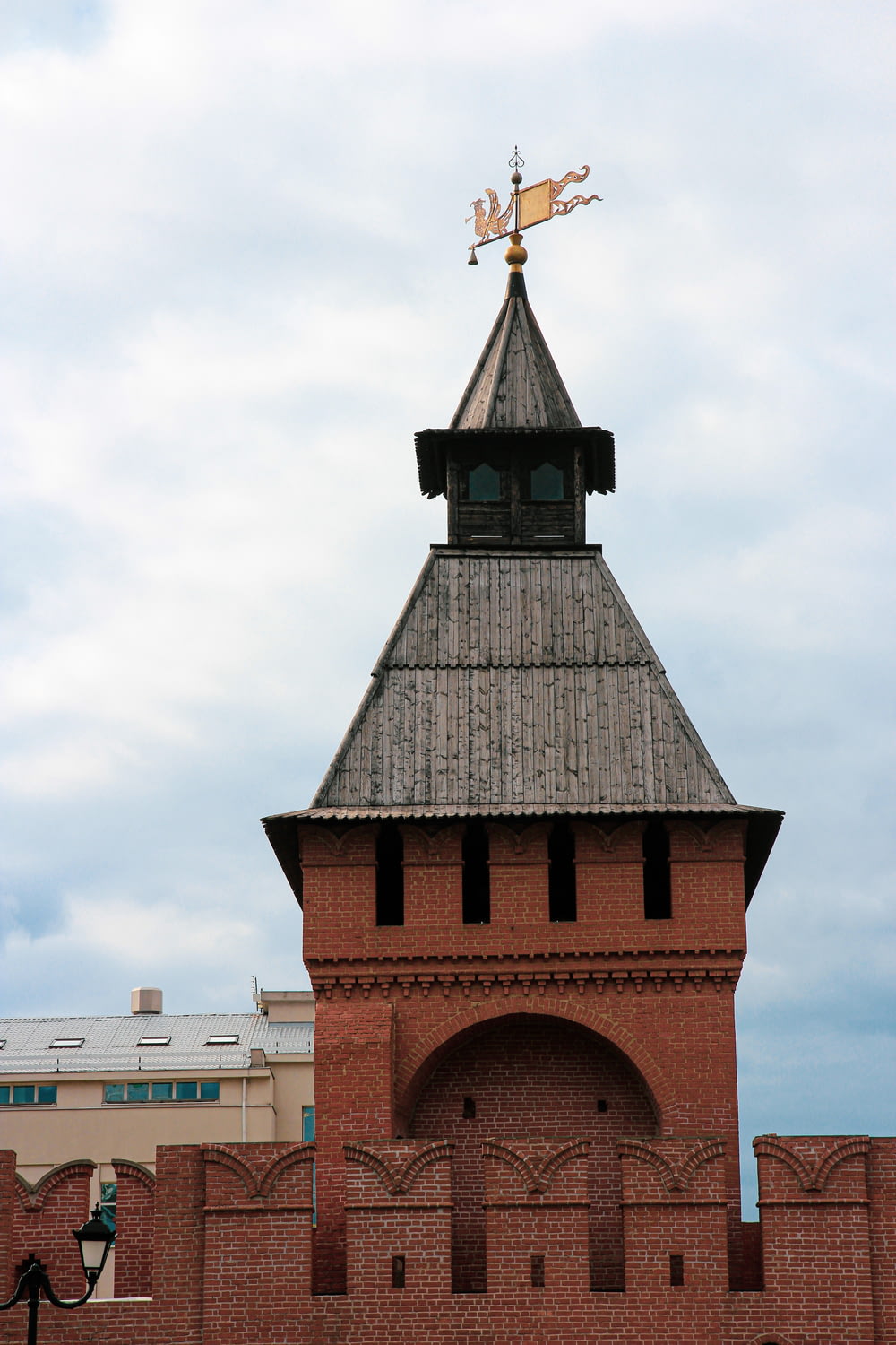 a tall brick tower with a weather vane on top