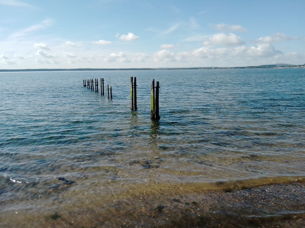 doca de madeira marrom no mar sob o céu azul durante o dia