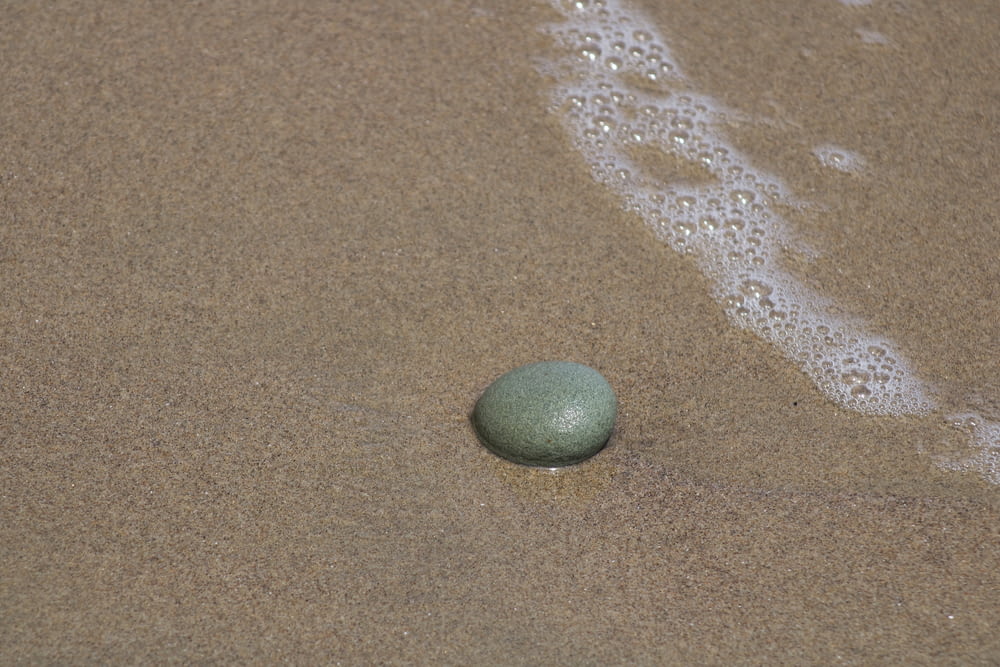 green round ball on brown sand