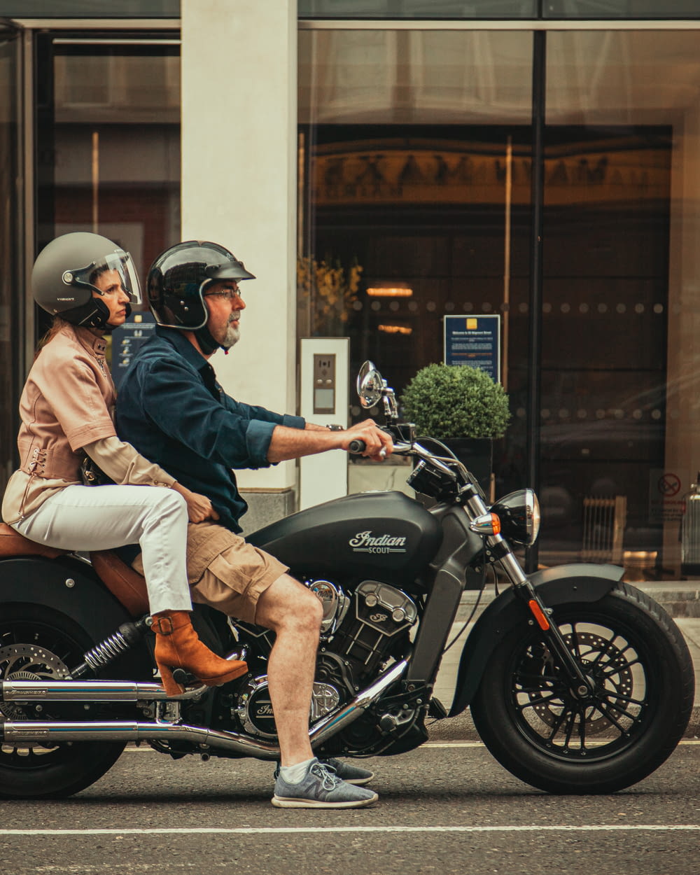 man in blue denim jacket and brown pants riding black and gray motorcycle