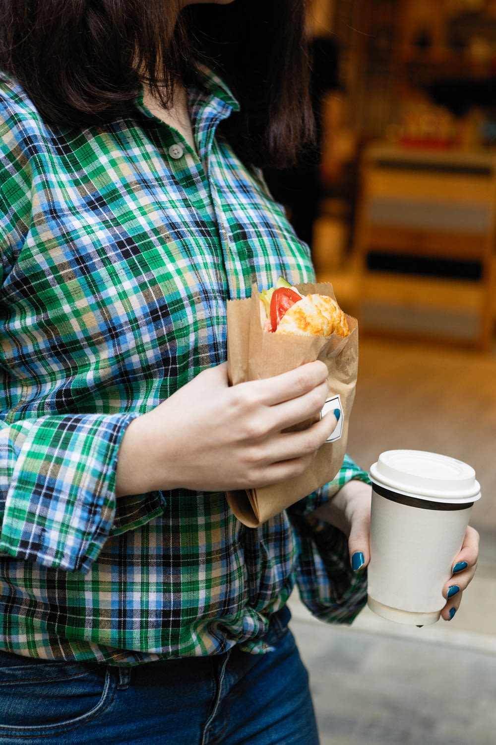 pessoa em azul vermelho e branco xadrez camisa social segurando pão