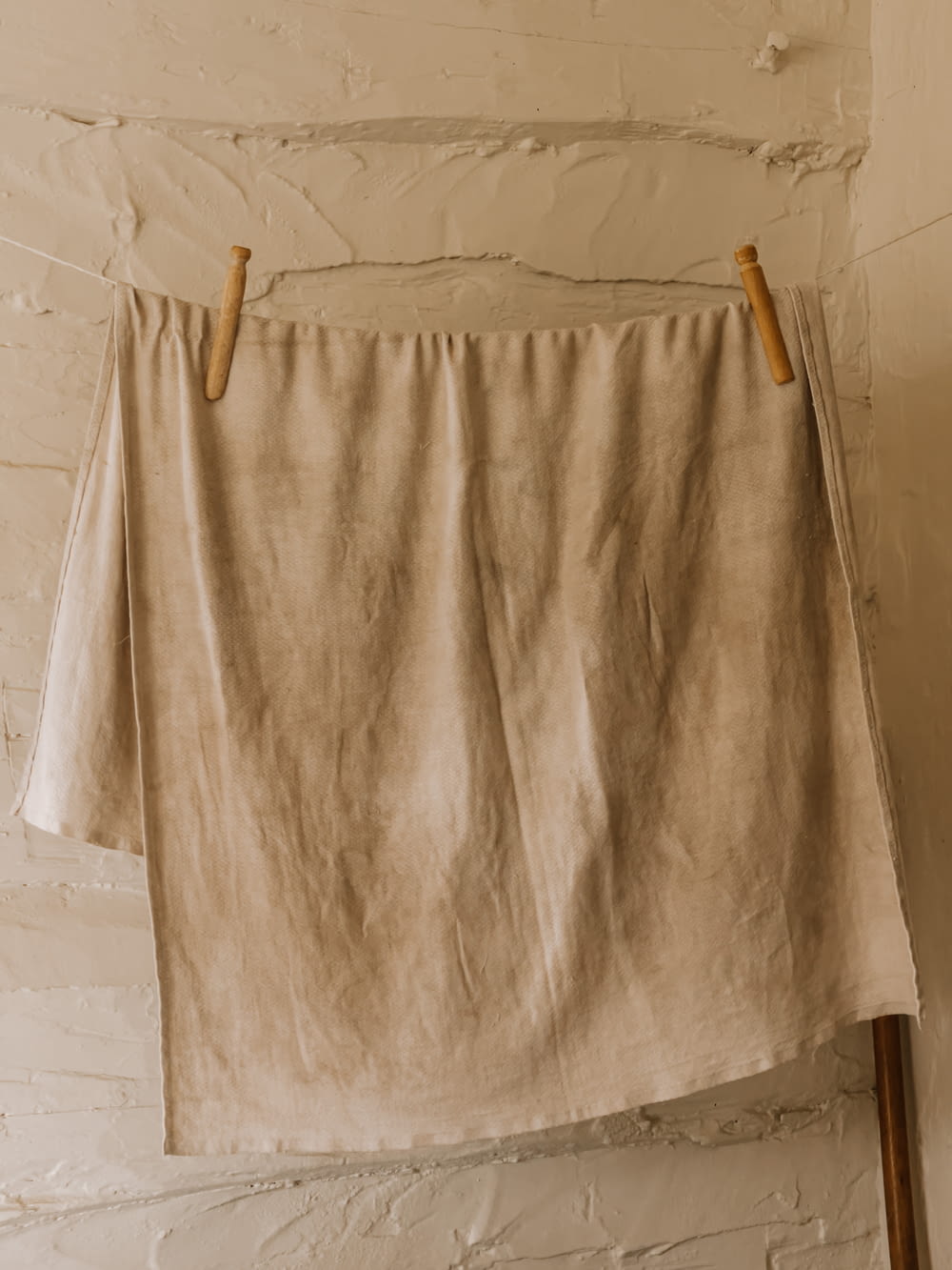 white bath towel on brown wooden clothes hanger