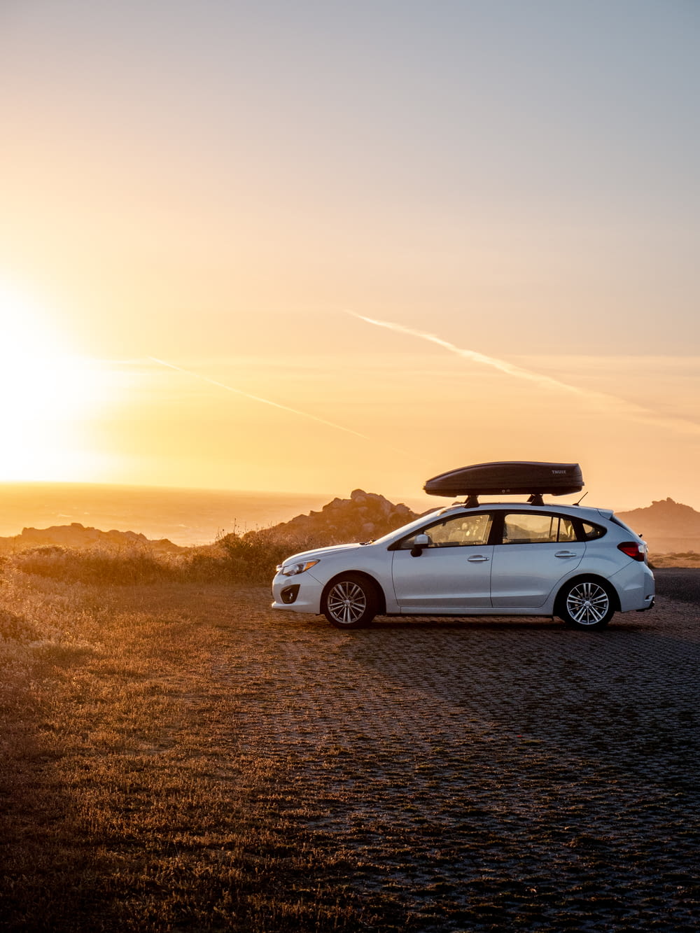 Chevrolet Camaro blanche sur la route au coucher du soleil