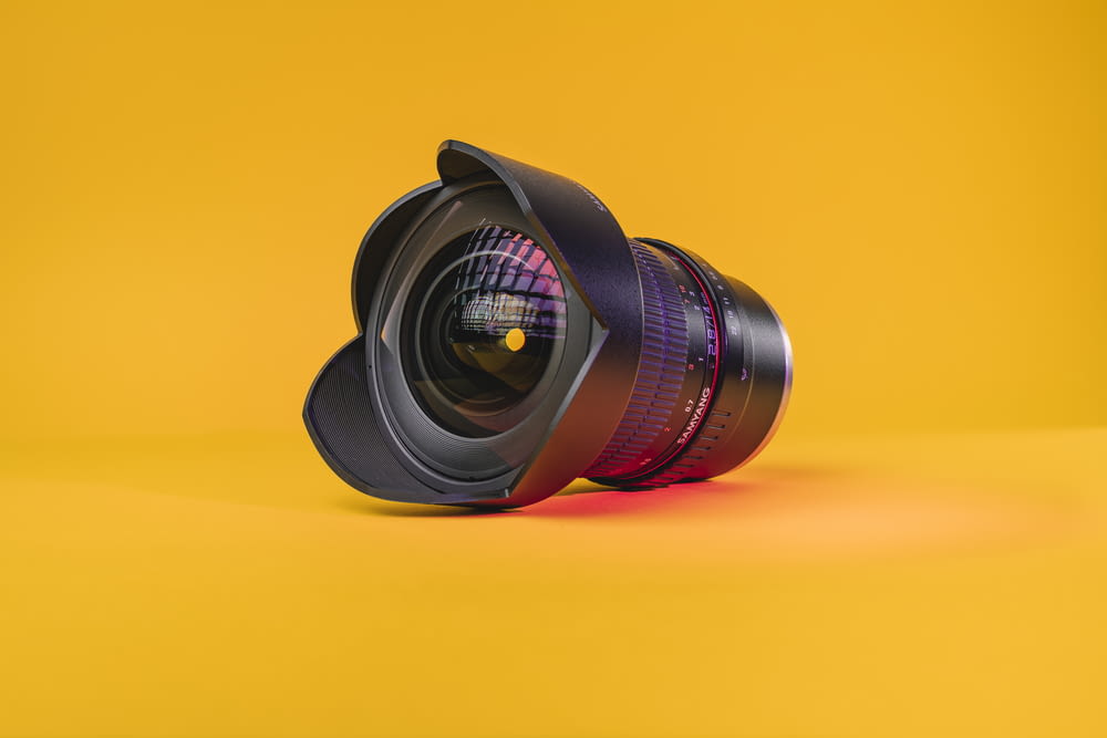 black camera lens on yellow surface
