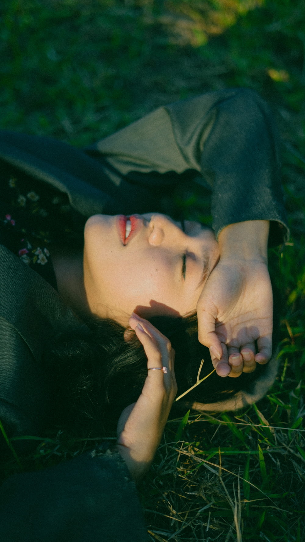 woman in green long sleeve shirt lying on green grass