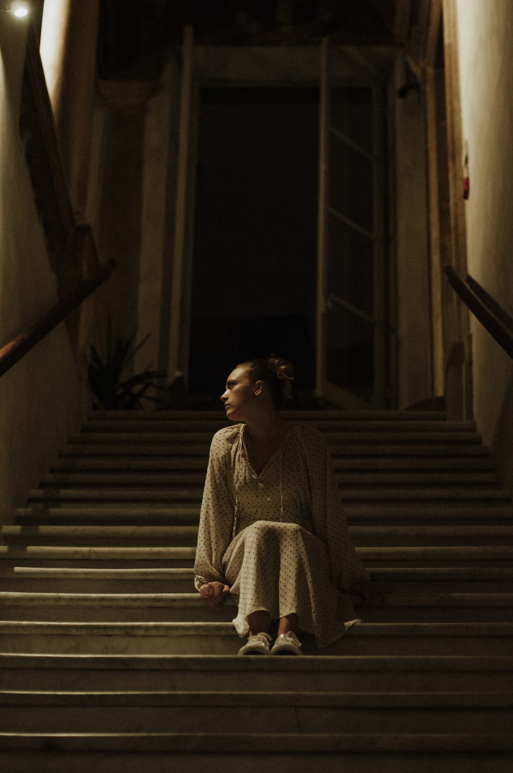 woman in white and black long sleeve dress sitting on staircase