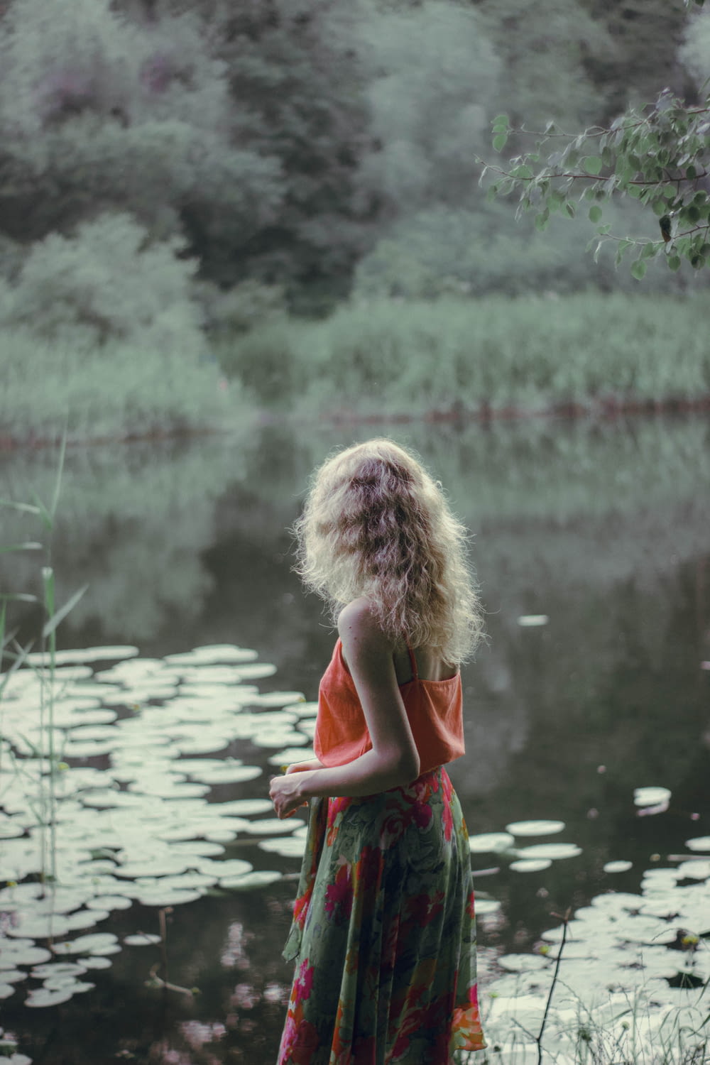 girl in red and green dress standing on water during daytime
