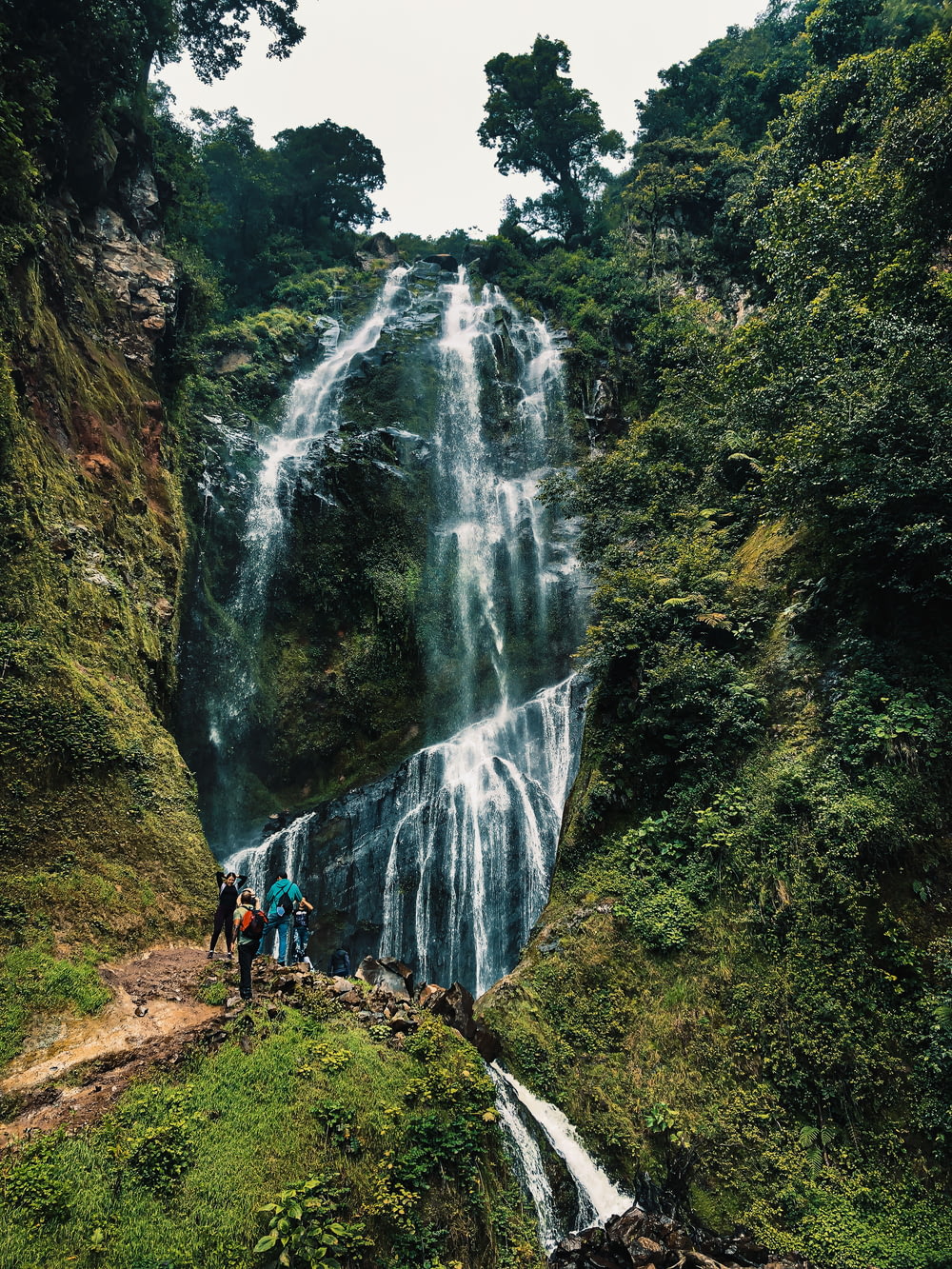 people walking on pathway near waterfalls during daytime