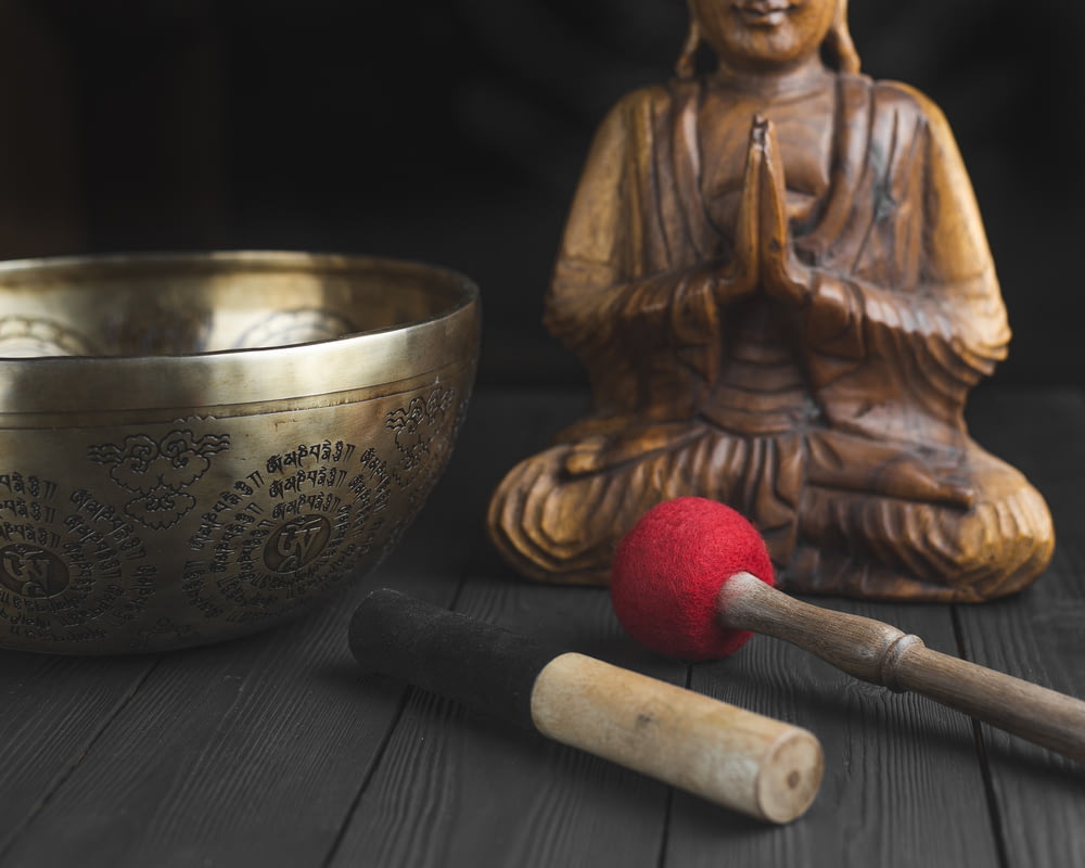 Figurine de Bouddha en laiton à côté du bâton rouge et blanc
