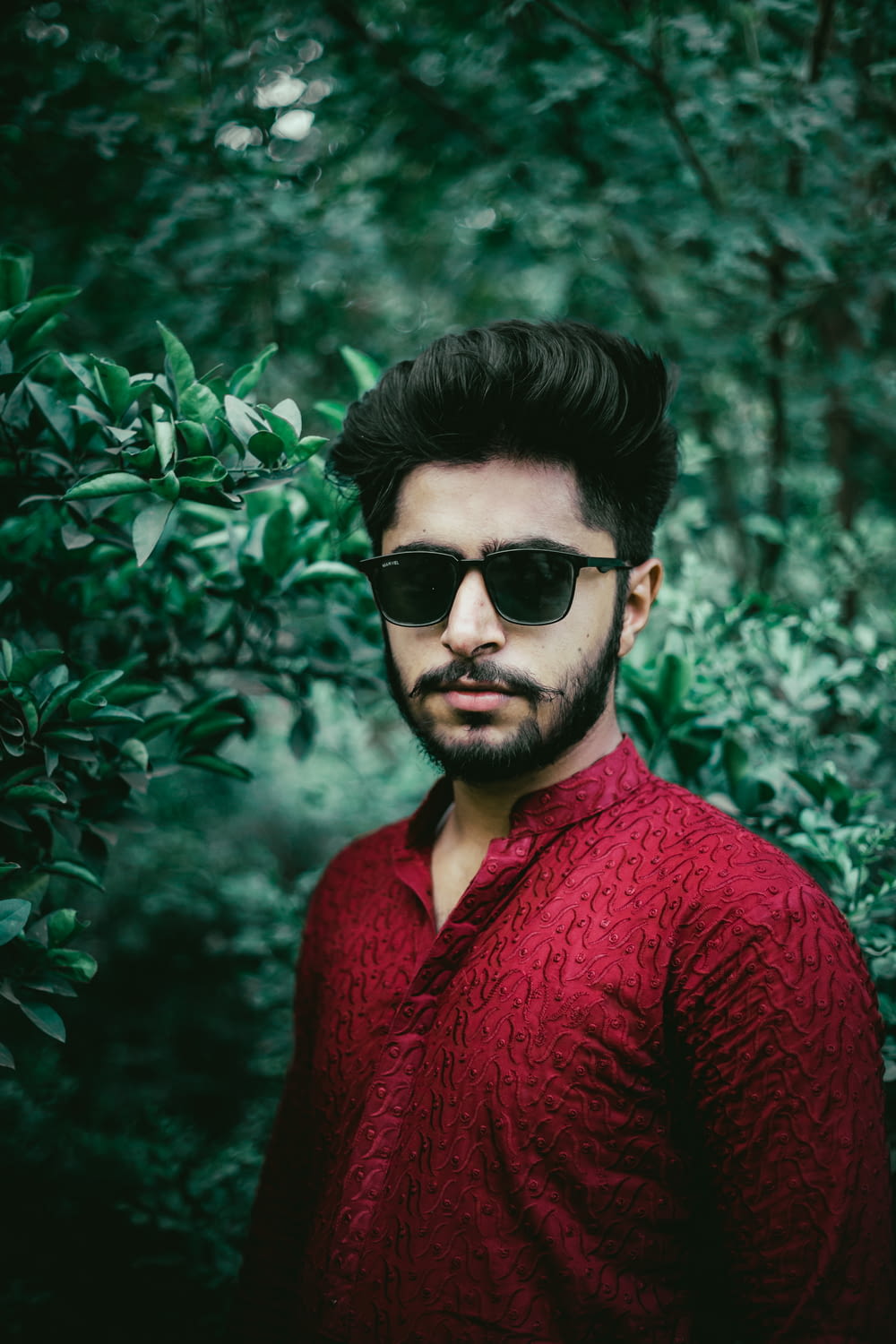 man in red v neck sweater wearing black sunglasses