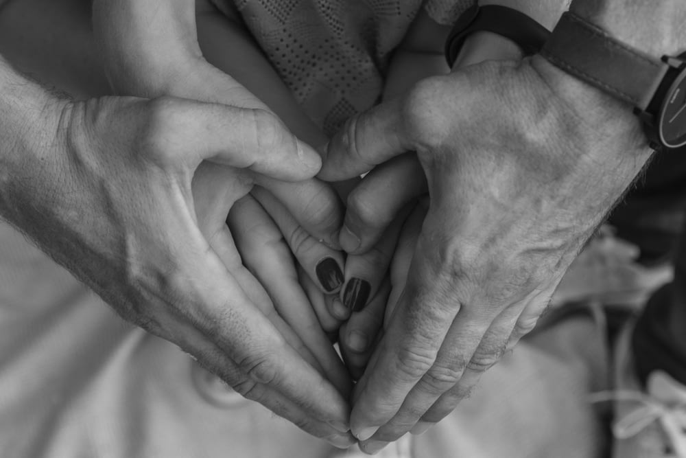 grayscale photo of couple holding hands