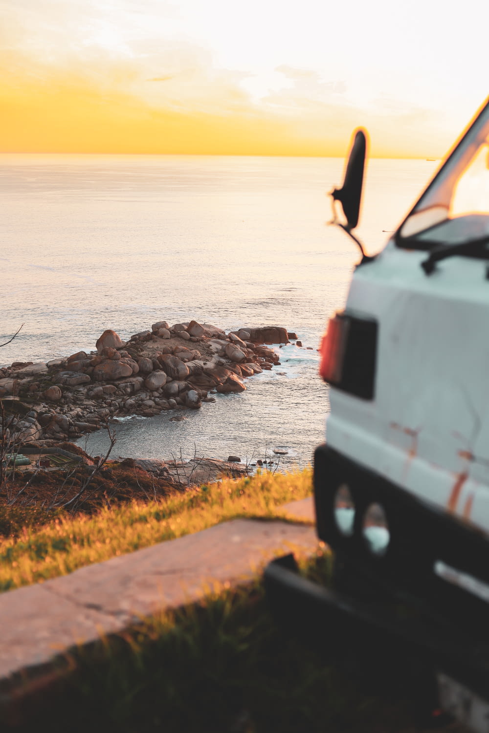 white van on seashore during sunset