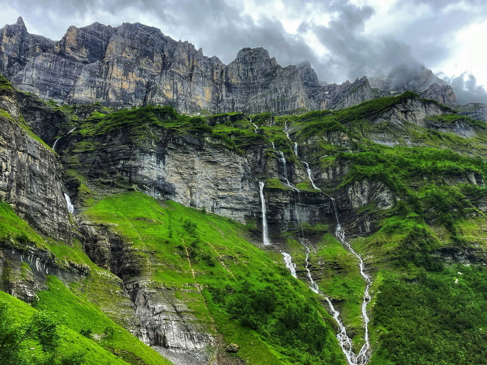 waterfalls on green grass covered mountain during daytime