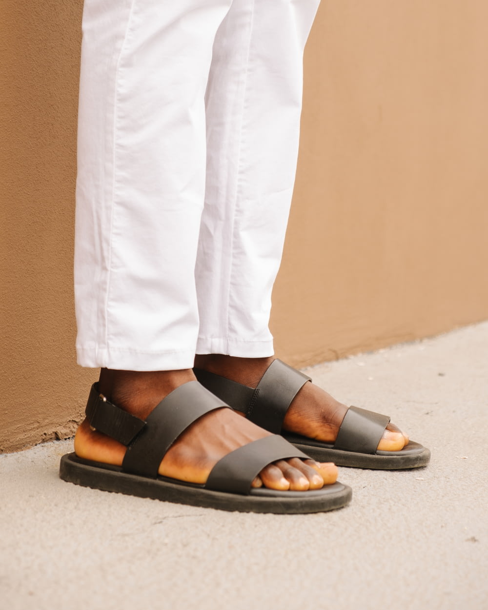 person wearing black leather sandals