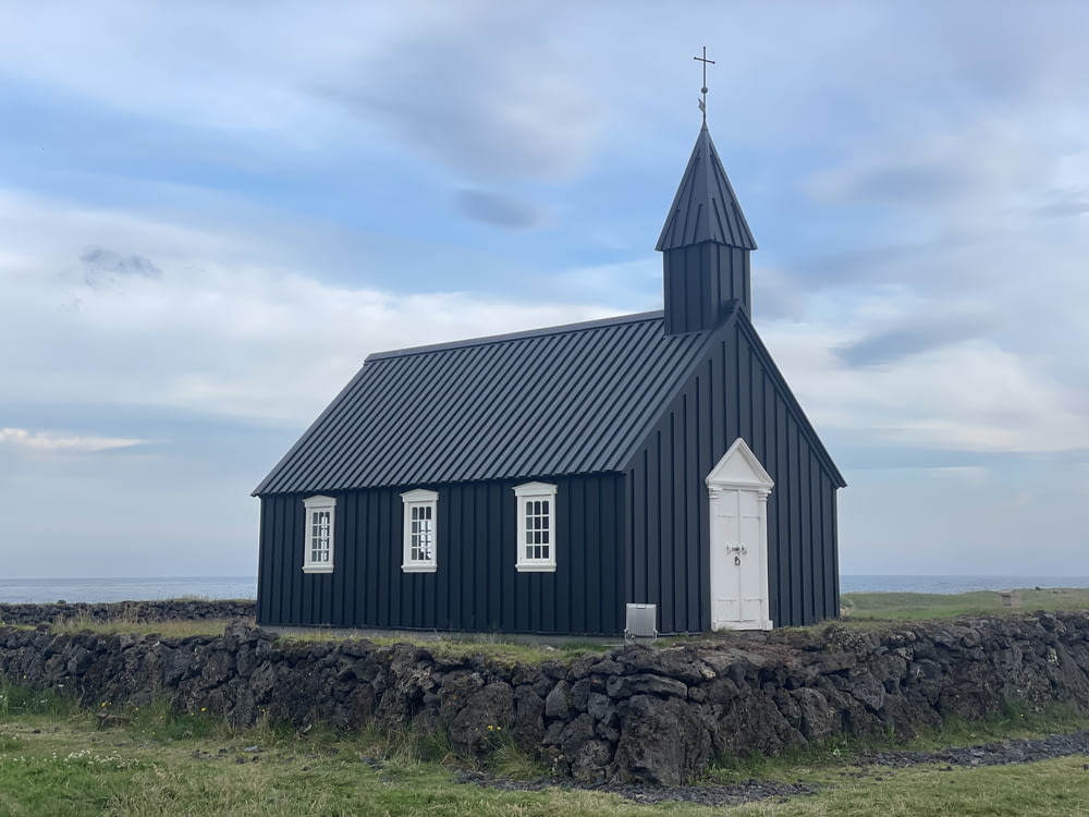 chiesa di legno in bianco e nero sul campo di erba verde sotto nuvole bianche e cielo blu durante