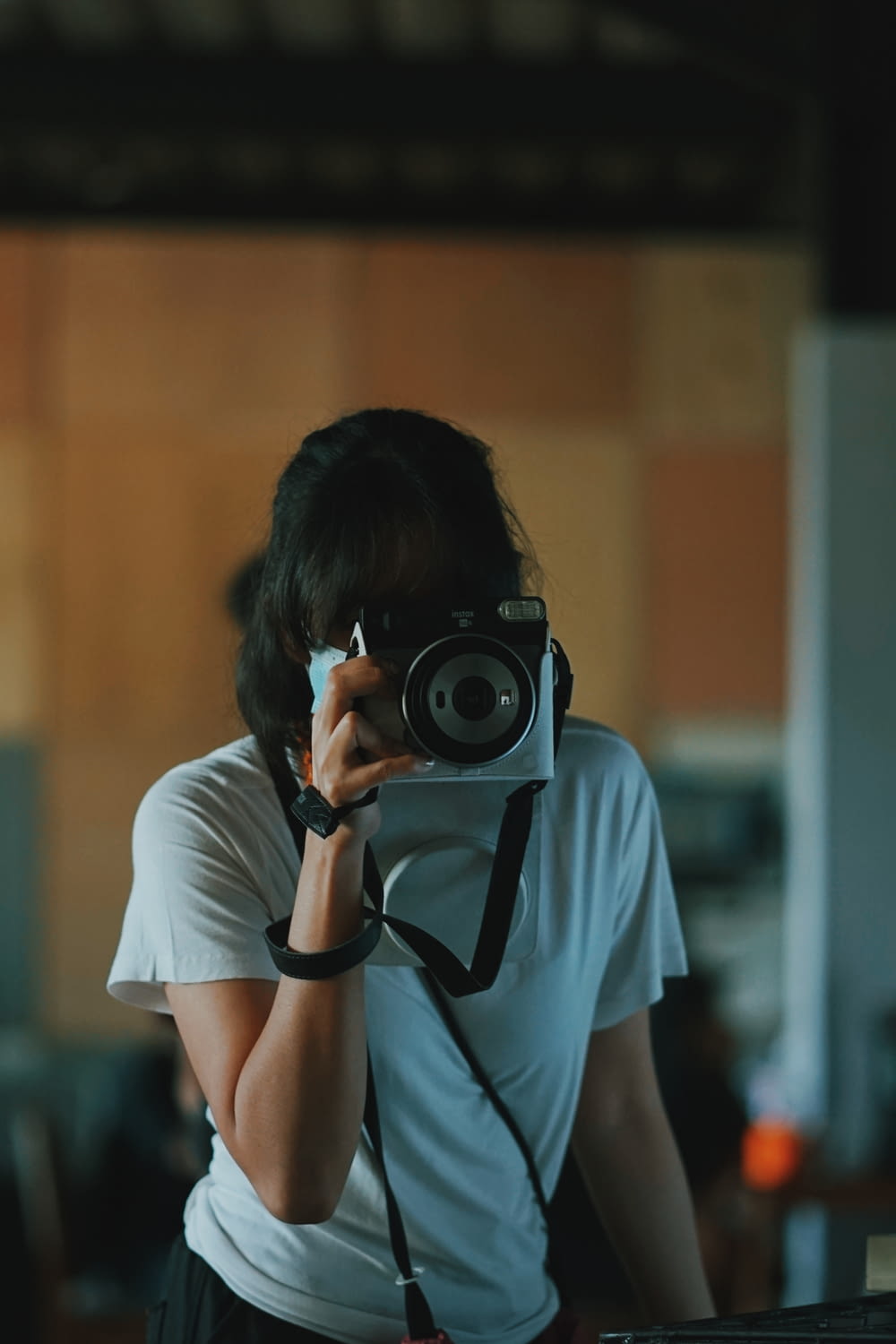 woman in white t-shirt holding black camera