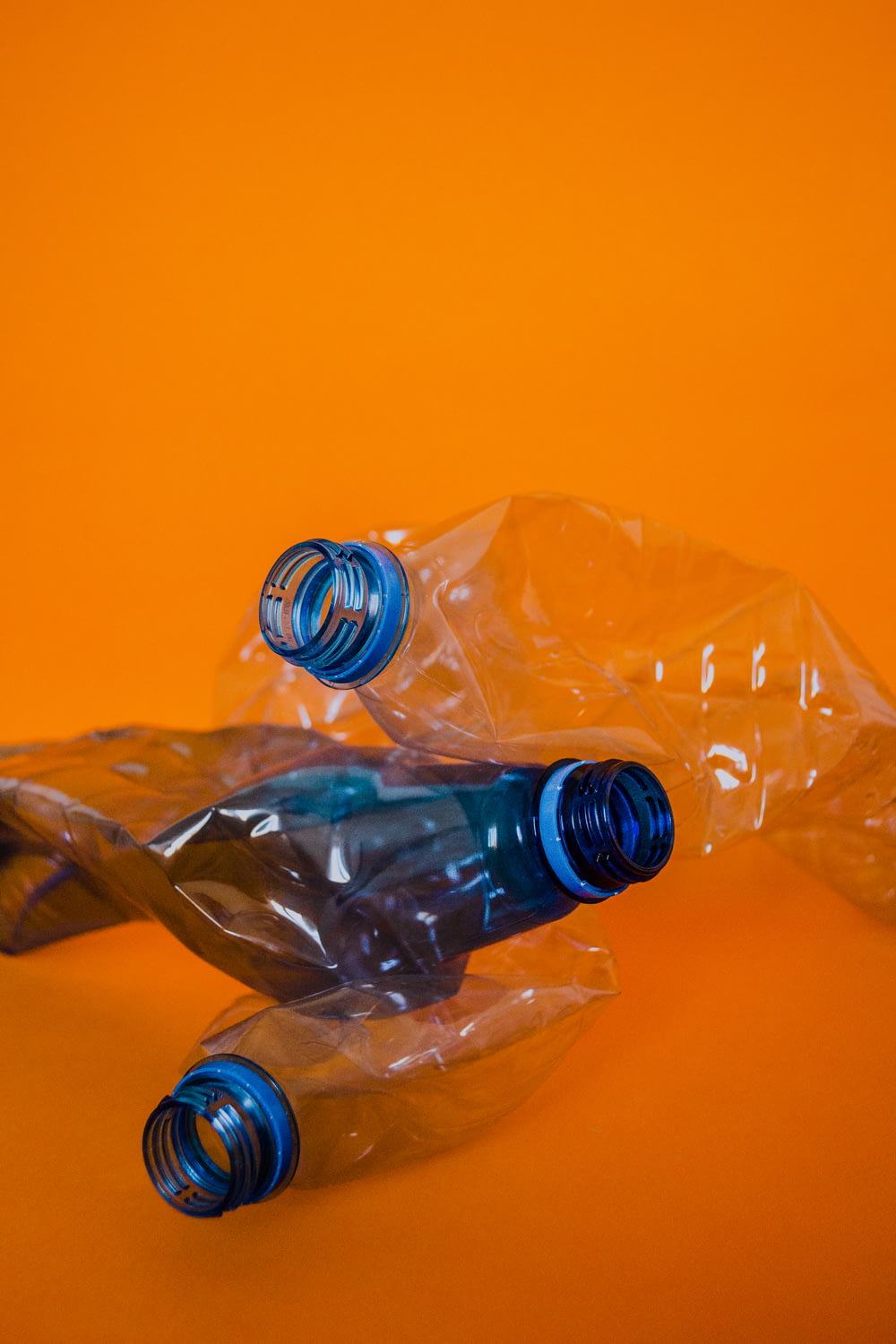 blaue Plastikflasche auf orangefarbener Oberfläche