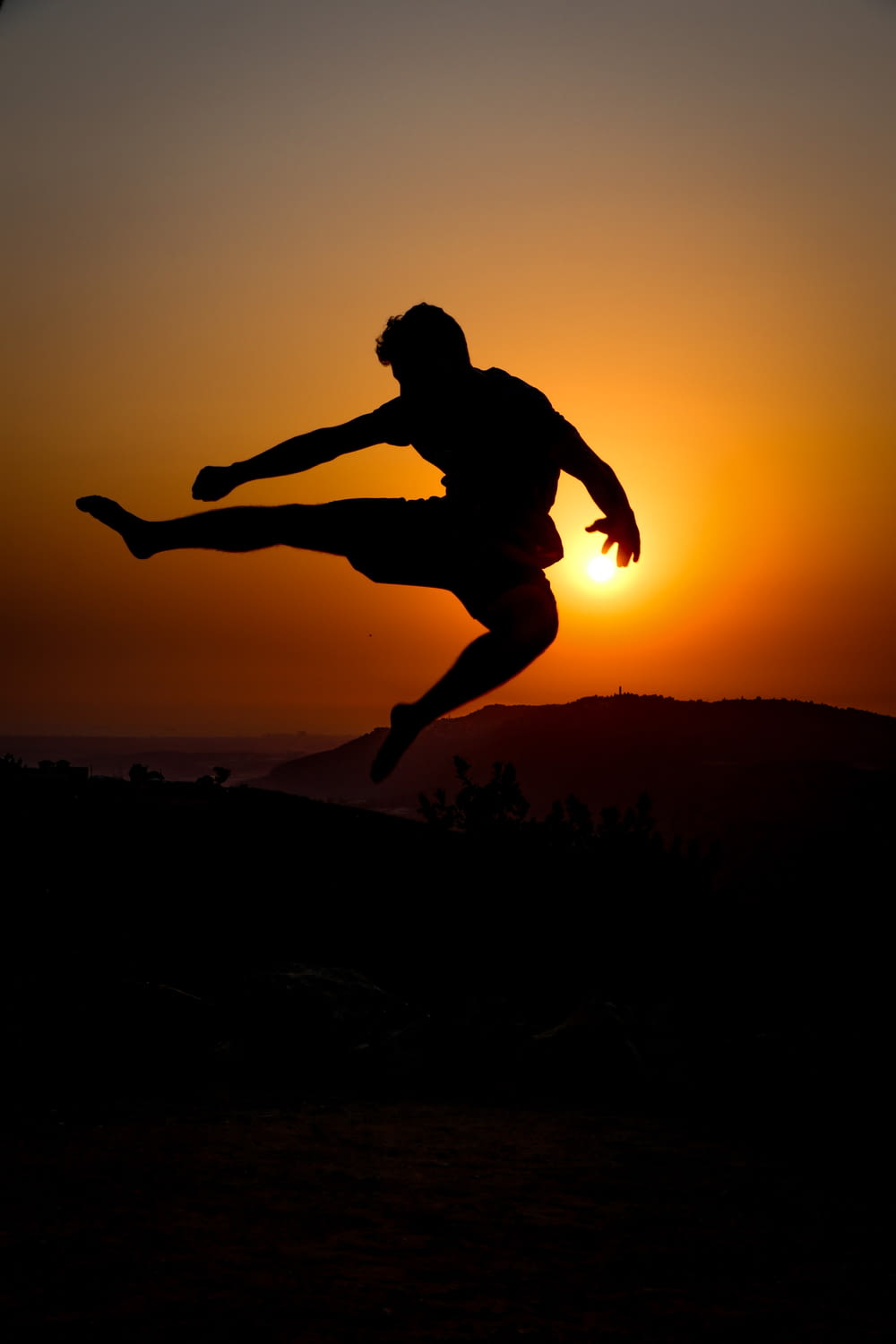 silhouette of man jumping during sunset