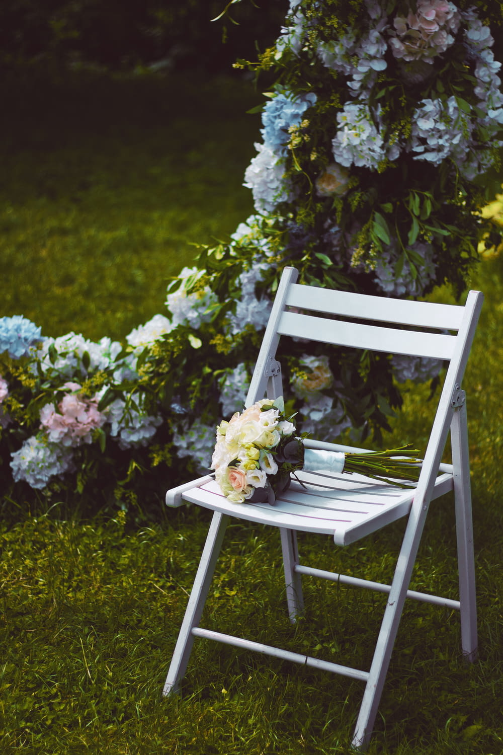 flores brancas e amarelas na cadeira de madeira branca