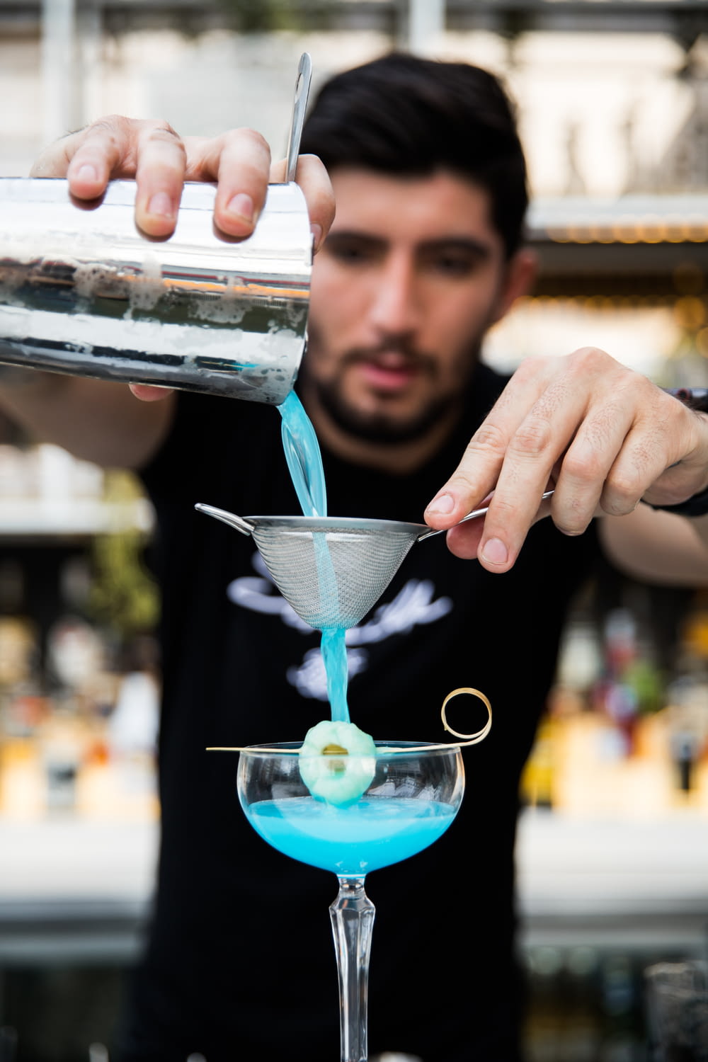 Mujer sosteniendo una taza de vidrio transparente con líquido azul