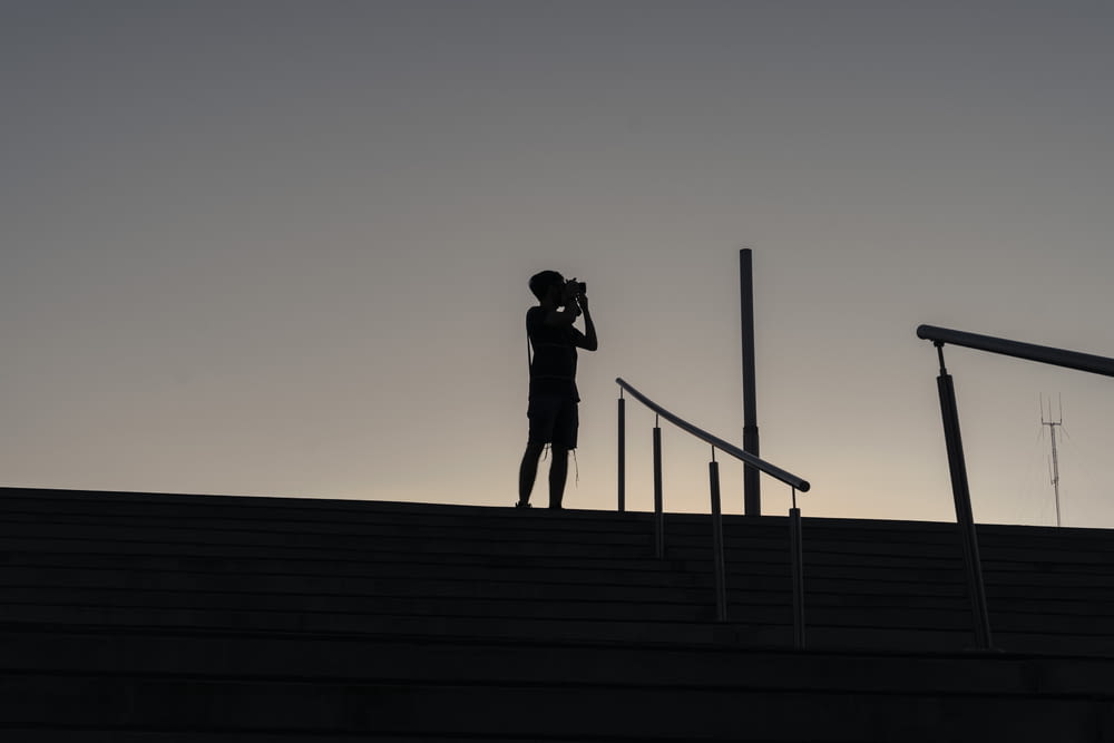 silhouette of man and woman kissing on wooden dock during sunset