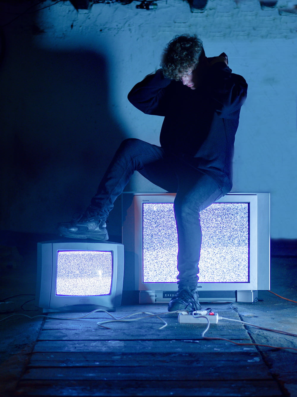a man sitting on top of a tv set