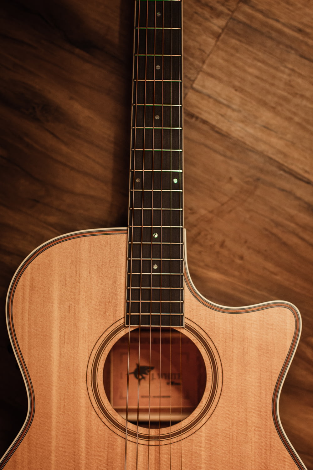 braune Akustikgitarre auf braunem Holzboden