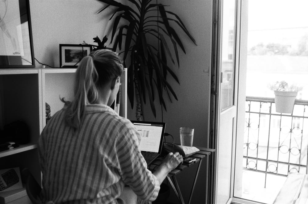 woman in striped long sleeve shirt using laptop computer