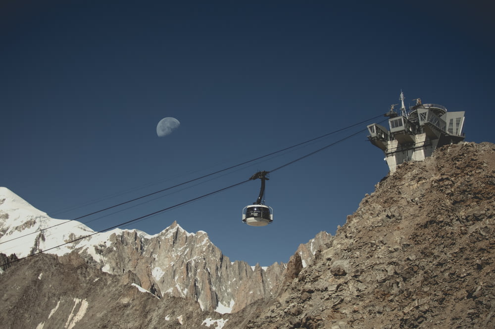 cable car over rocky mountain during daytime