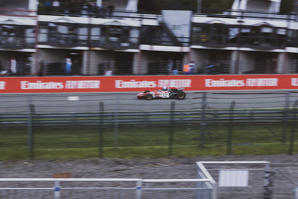 red and white racing car on track field during daytime