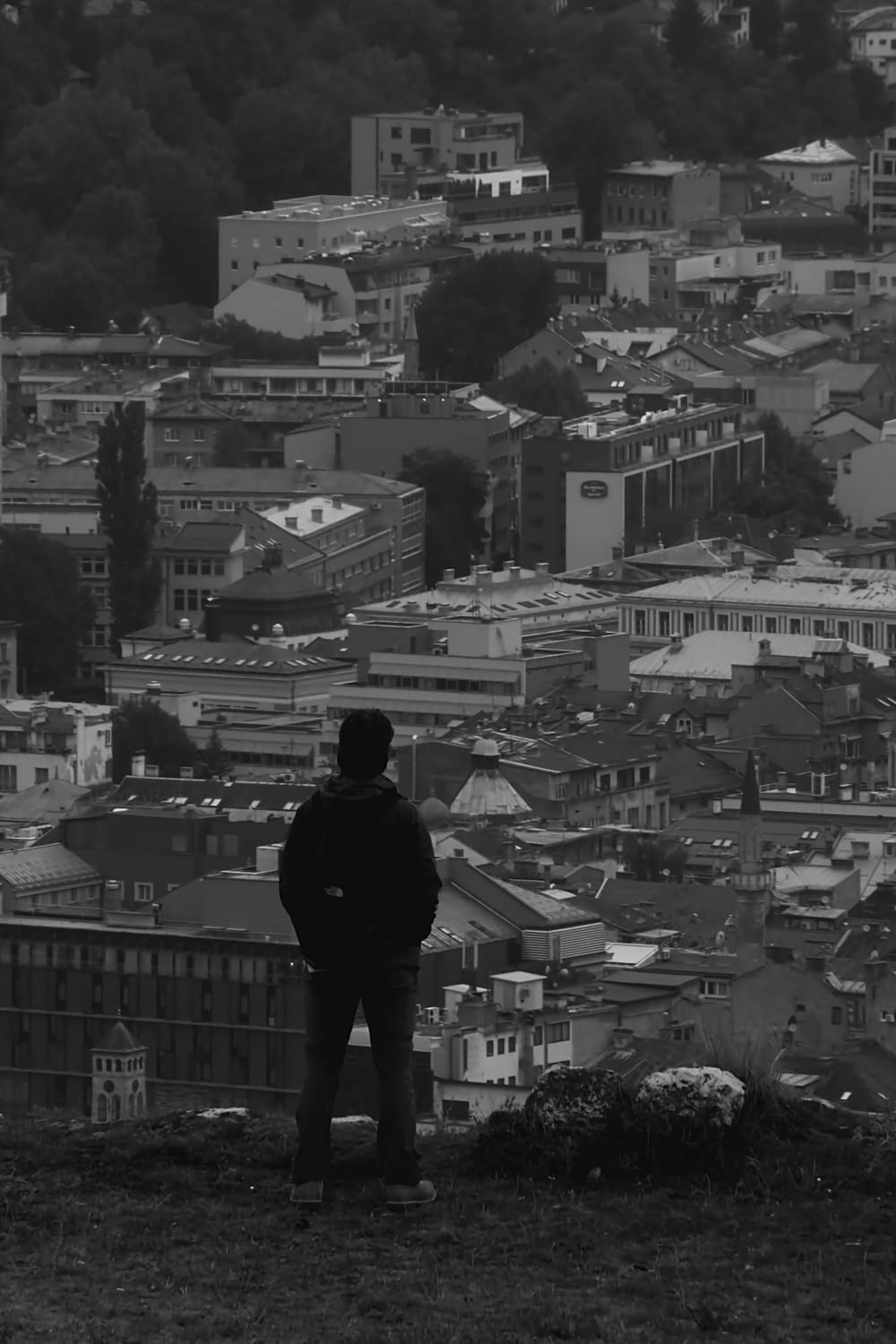 man in black jacket standing on top of building
