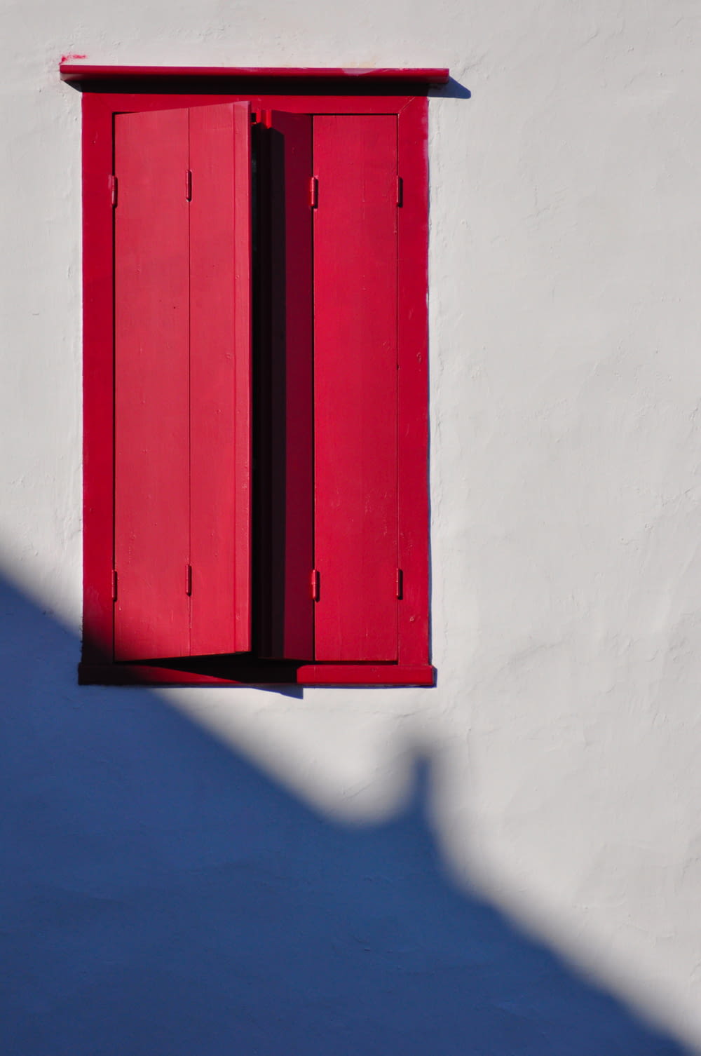 Porte en bois rouge sur mur blanc