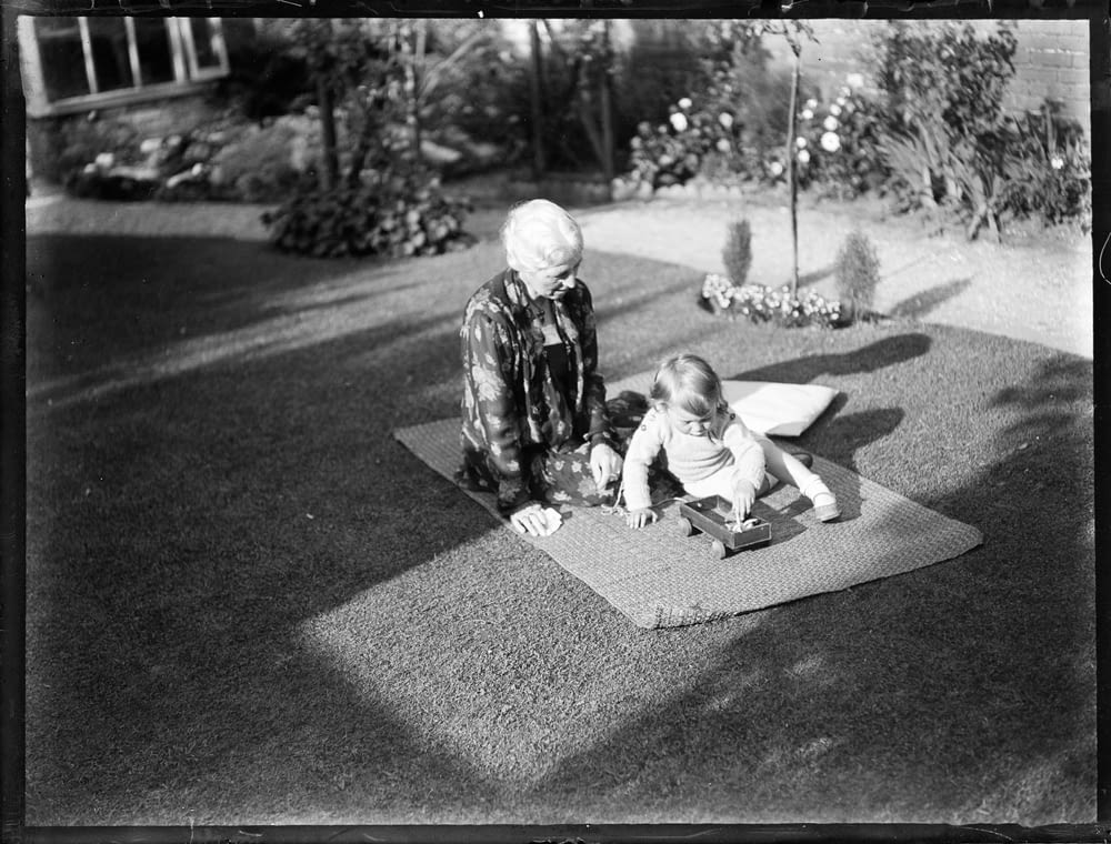 2 children sitting on the ground in grayscale photography