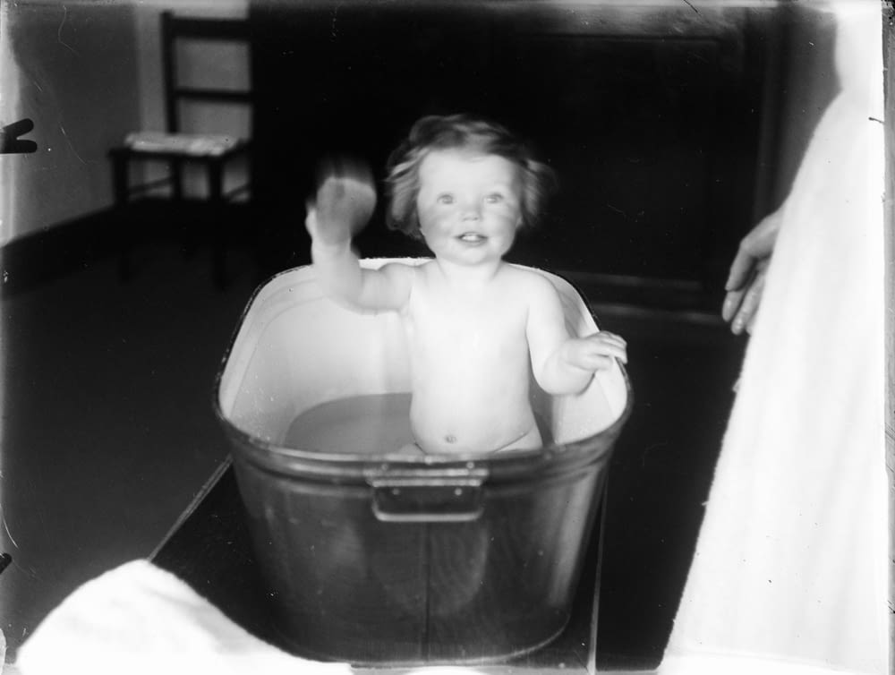 grayscale photo of 2 children in bucket