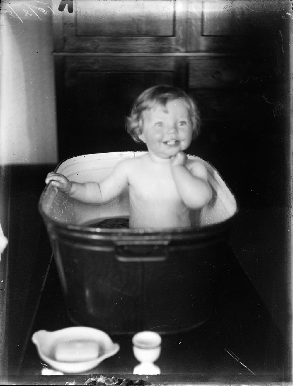 topless child in black plastic bucket