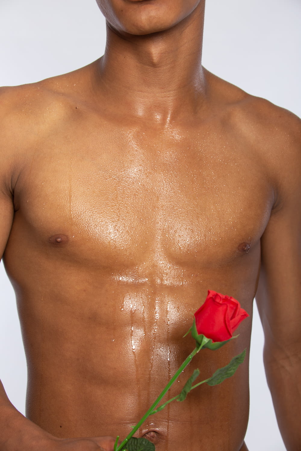 topless man with red rose on his chest