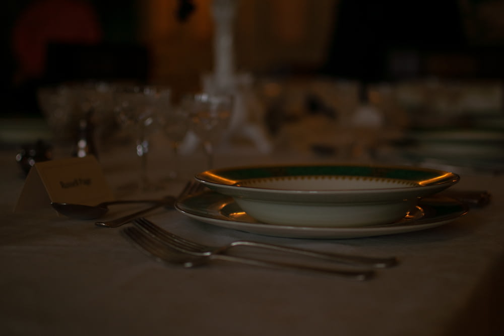 tenedor de plata y cuchillo de pan en plato de cerámica blanca
