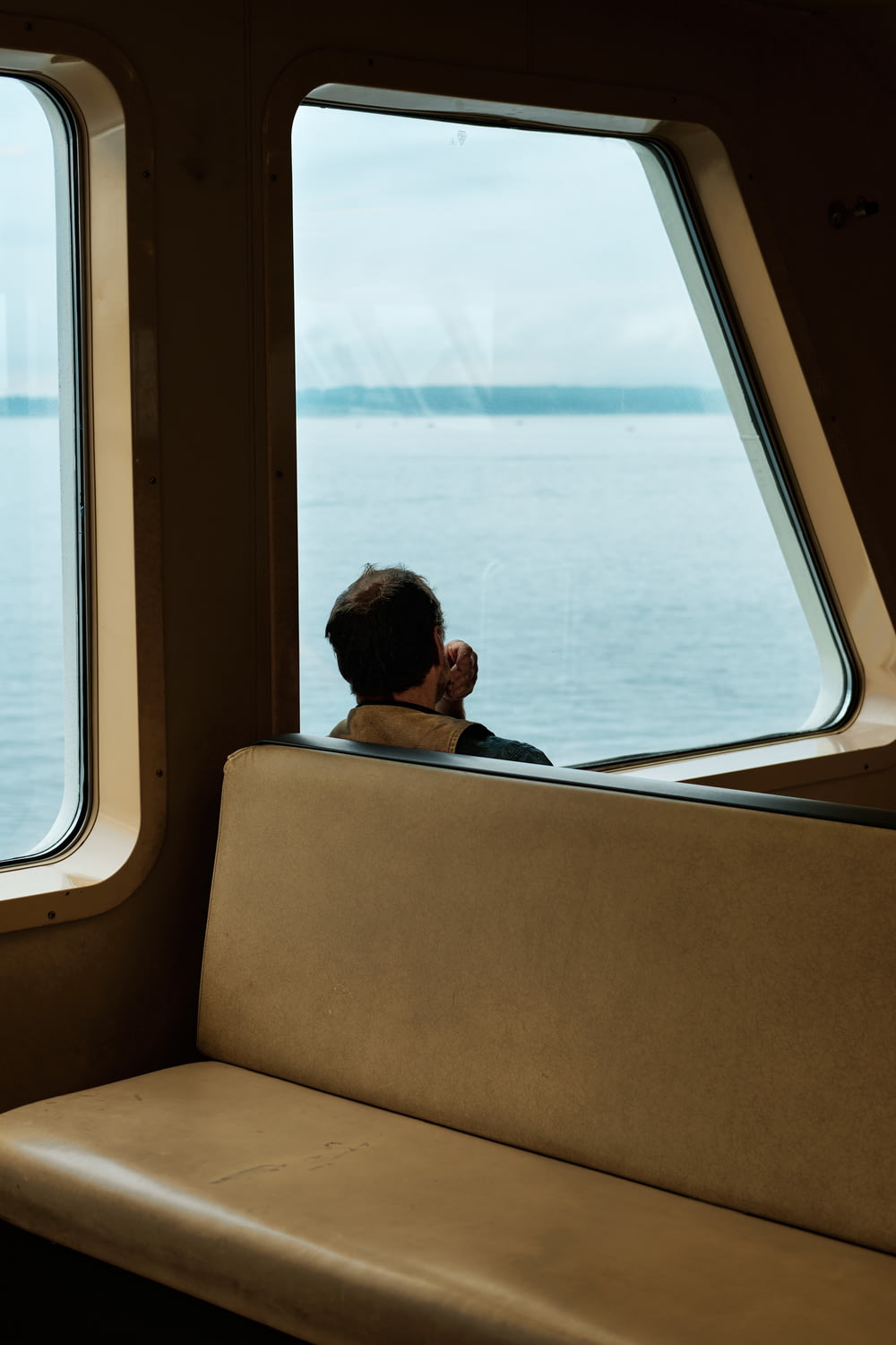 mulher na camisa preta sentada na janela de um barco durante o dia