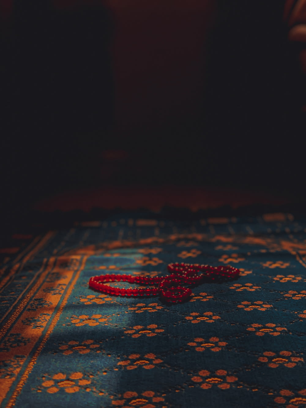 青い絨毯の上に置かれた赤い紐