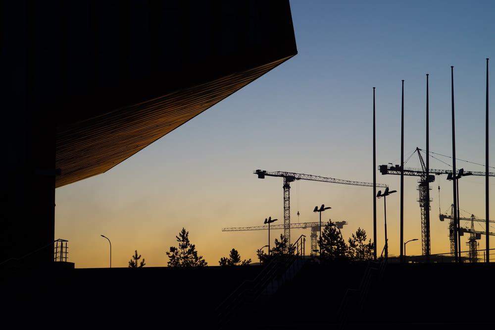 a group of cranes sitting next to a building under construction