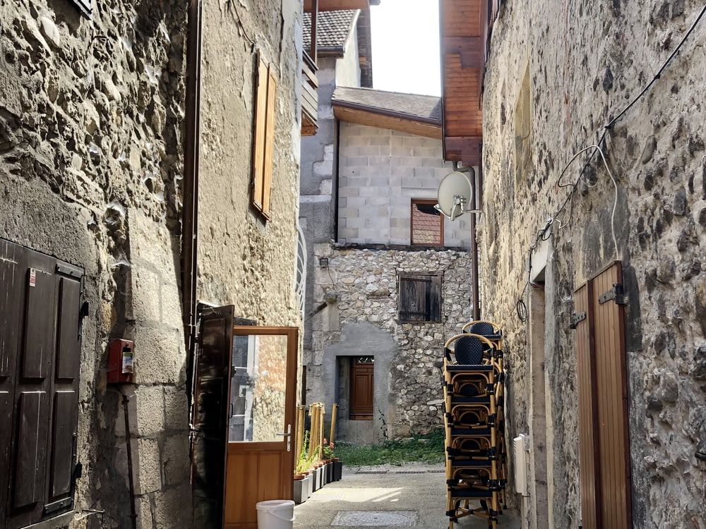a narrow alley way with a chair in between two buildings