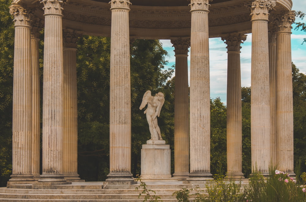 a statue of an angel on a pedestal surrounded by pillars