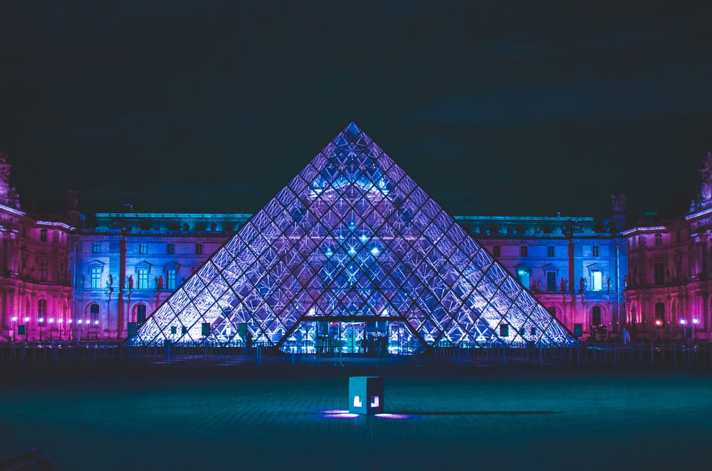 a large glass pyramid in front of a building