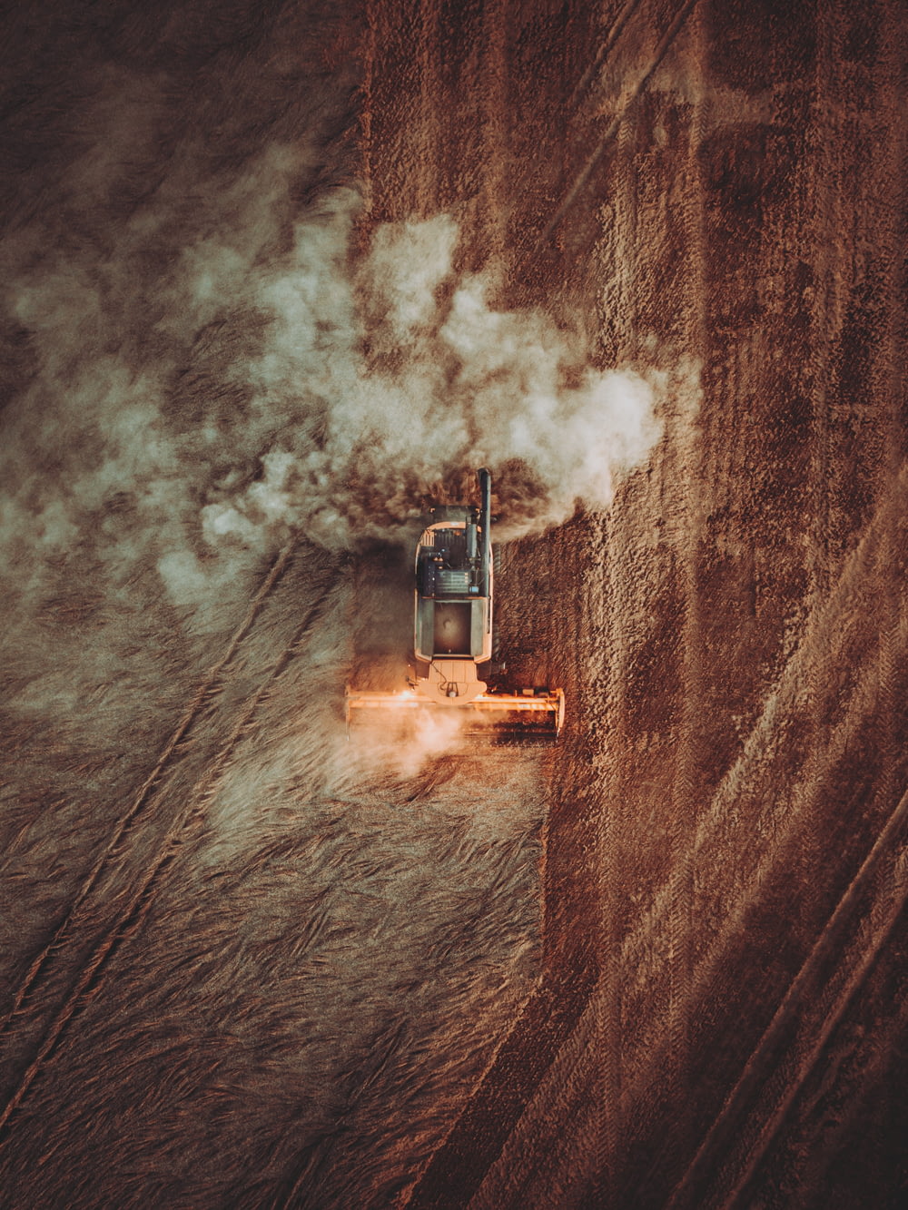 an aerial view of a tractor plowing a field