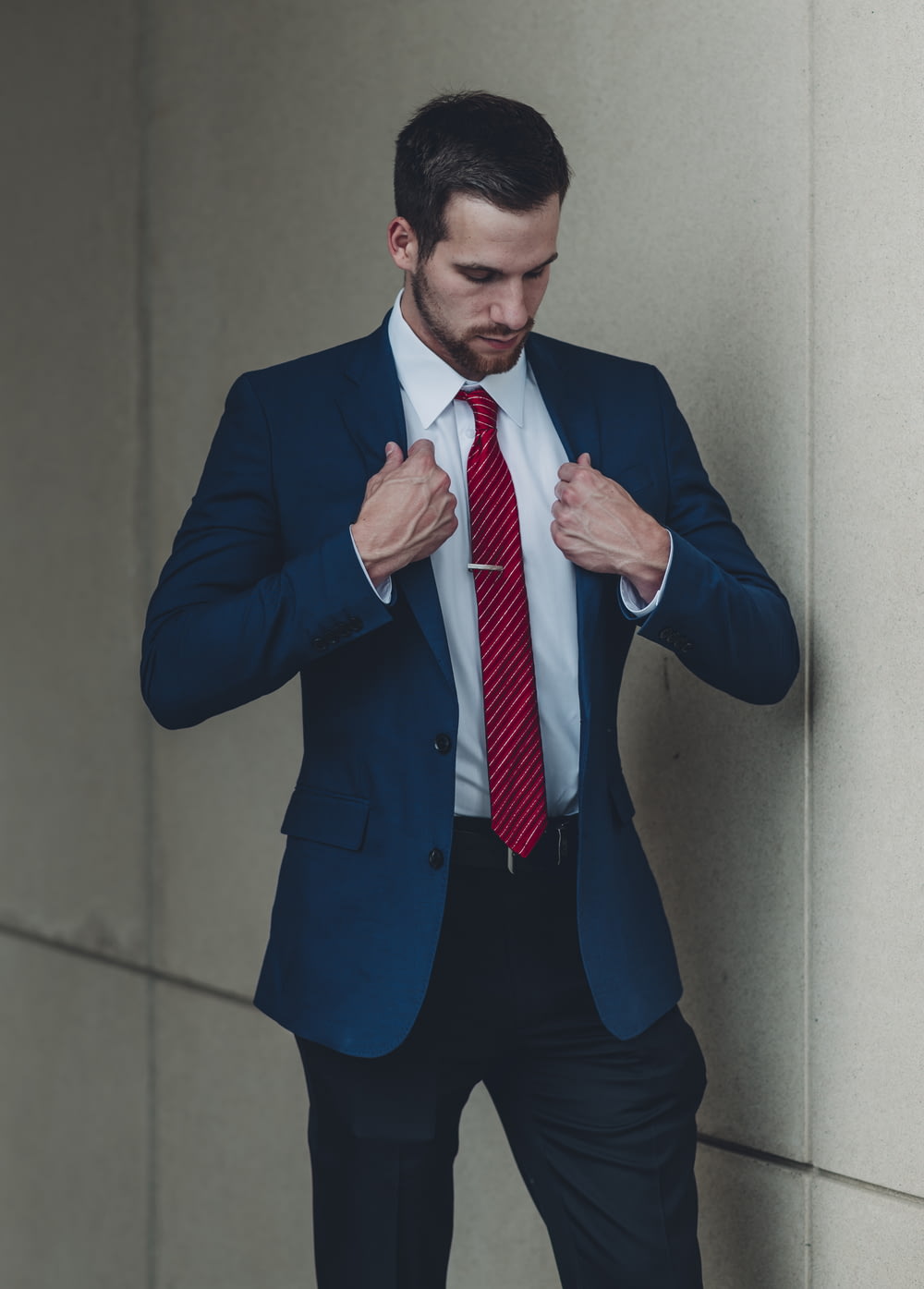 Un homme en costume et cravate rouge nouant sa cravate