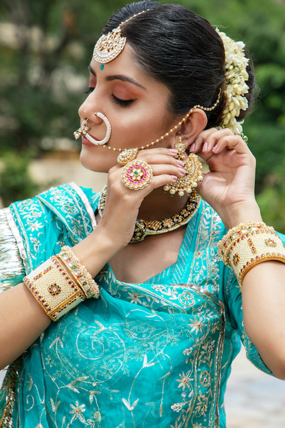 a woman in a blue sari with jewelry on her face
