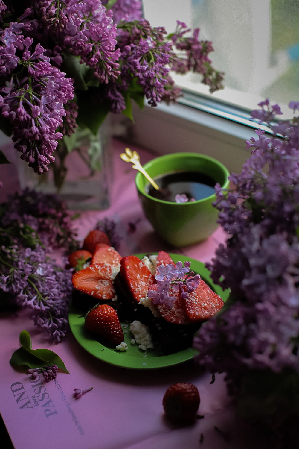 a plate of strawberries next to a cup of coffee