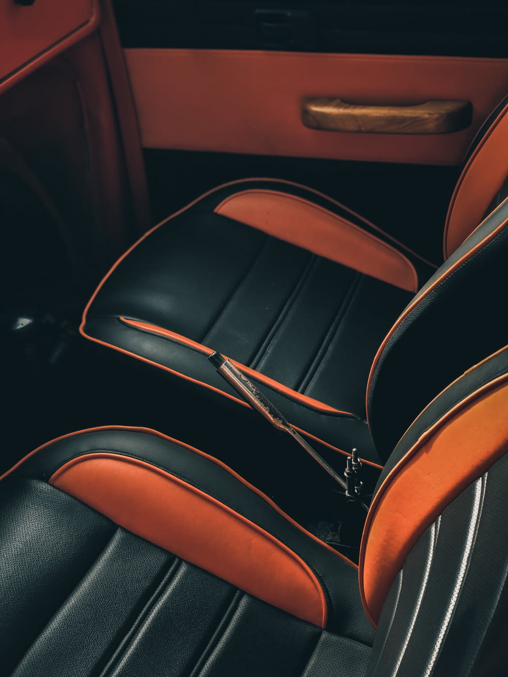 the interior of a car with black and orange seats