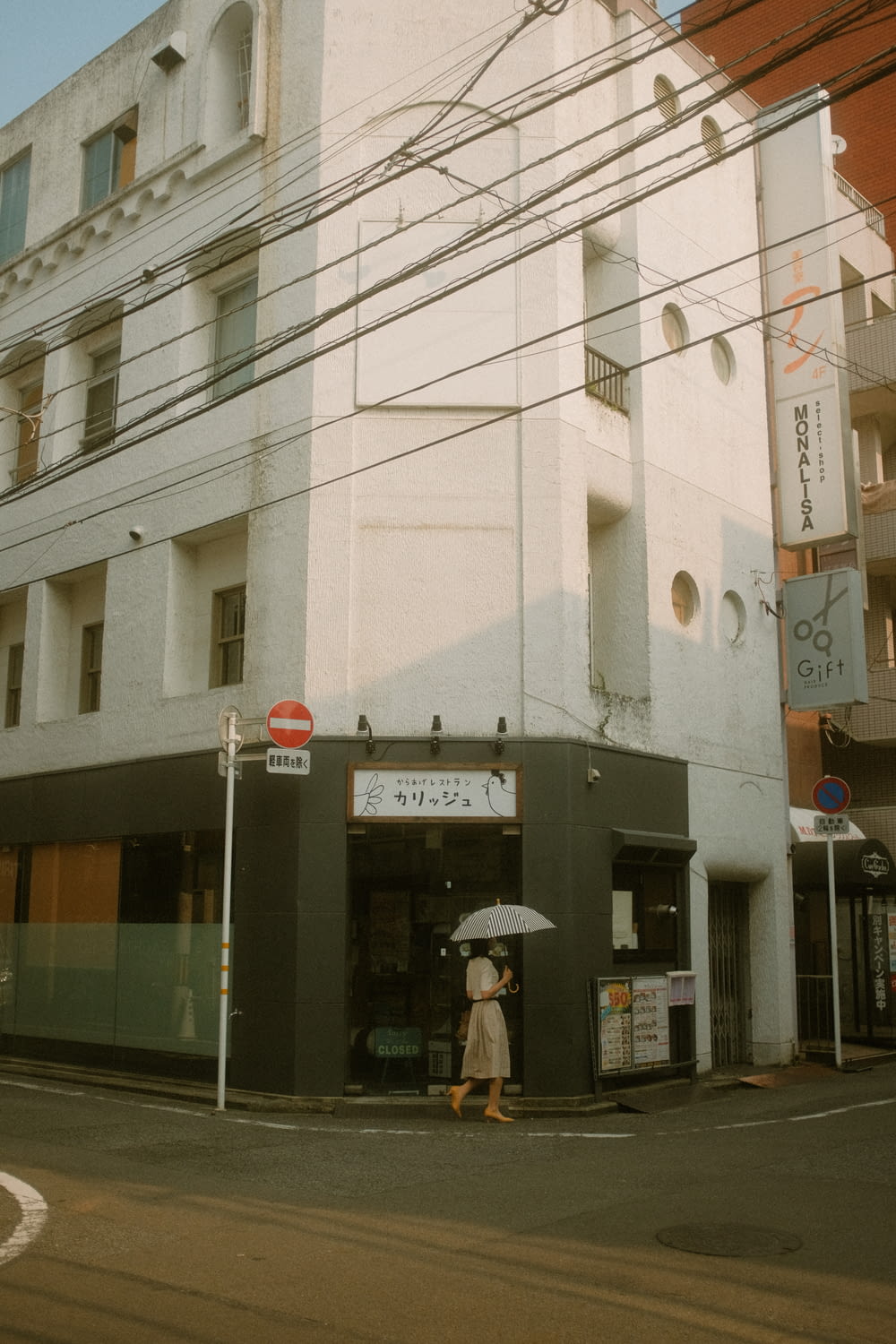 a woman holding an umbrella standing in front of a building
